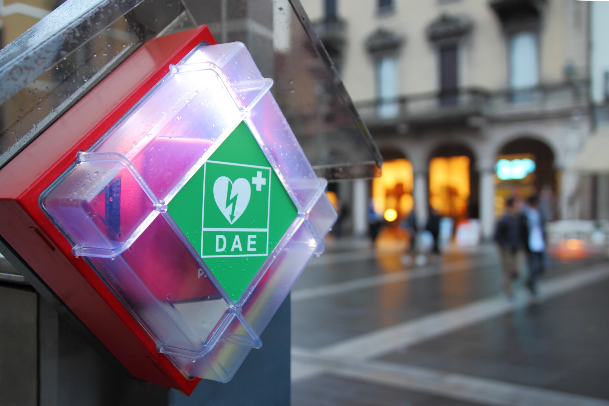 Una teca per defibrillatore con il cartello DAE in un luogo pubblico